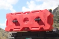 A red RotopaX fuel canister with a capacity of 4 gallons - the photo shows the canister mounted on the roof rack of an expedition vehicle